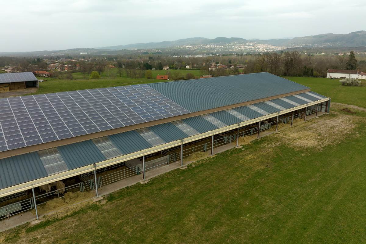 A farm building with solar panels mounted on rooftop for producing clean ecological electricity.